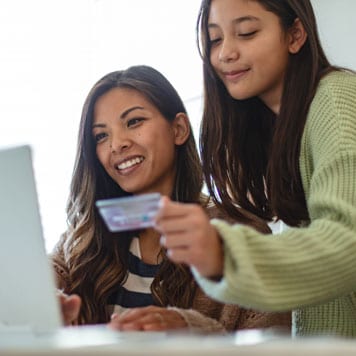 A person and a person looking at a laptop