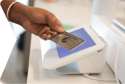 Person using AMEX card at a contactless payment terminal