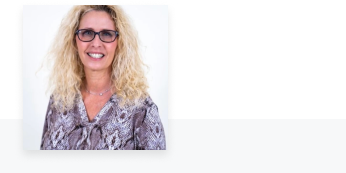 Woman in snakeskin patterned shirt smiling at camera