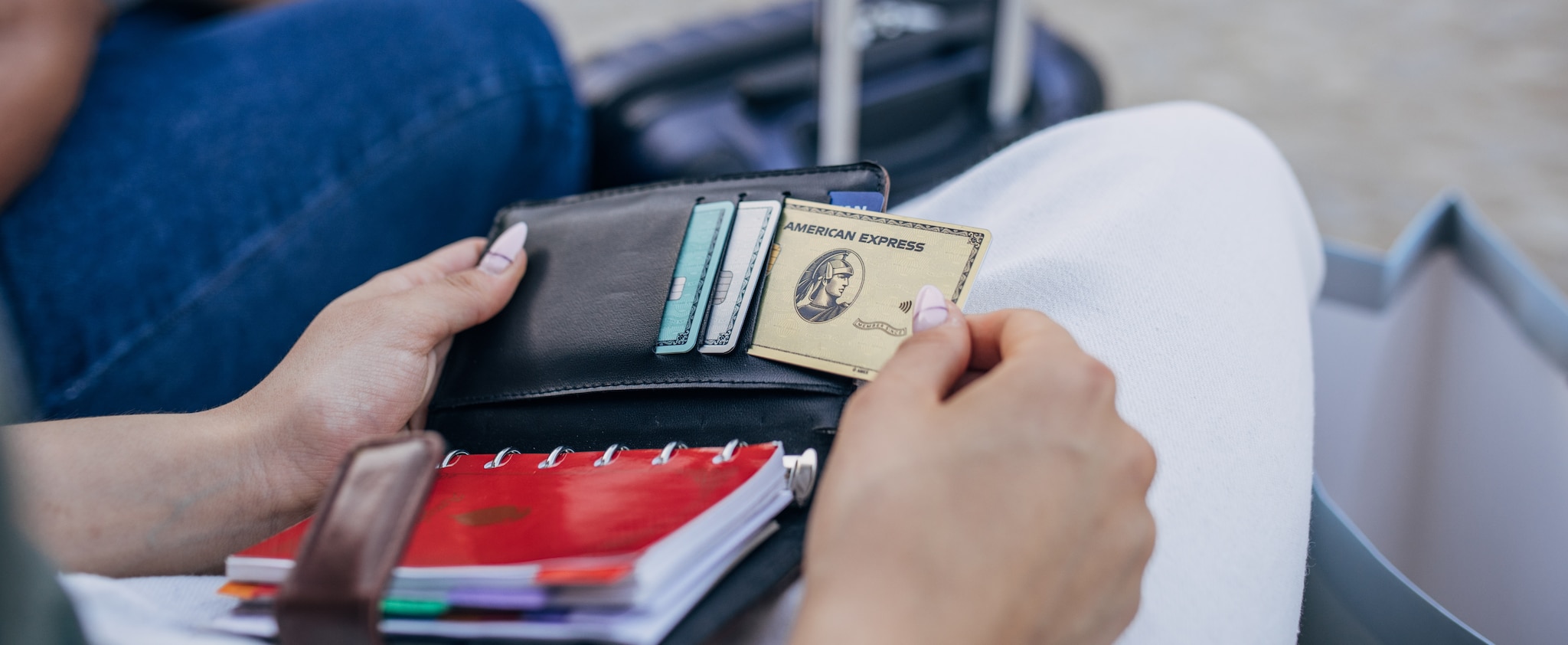 A person taking a credit card out of their wallet. A person taking a credit card out of their wallet.