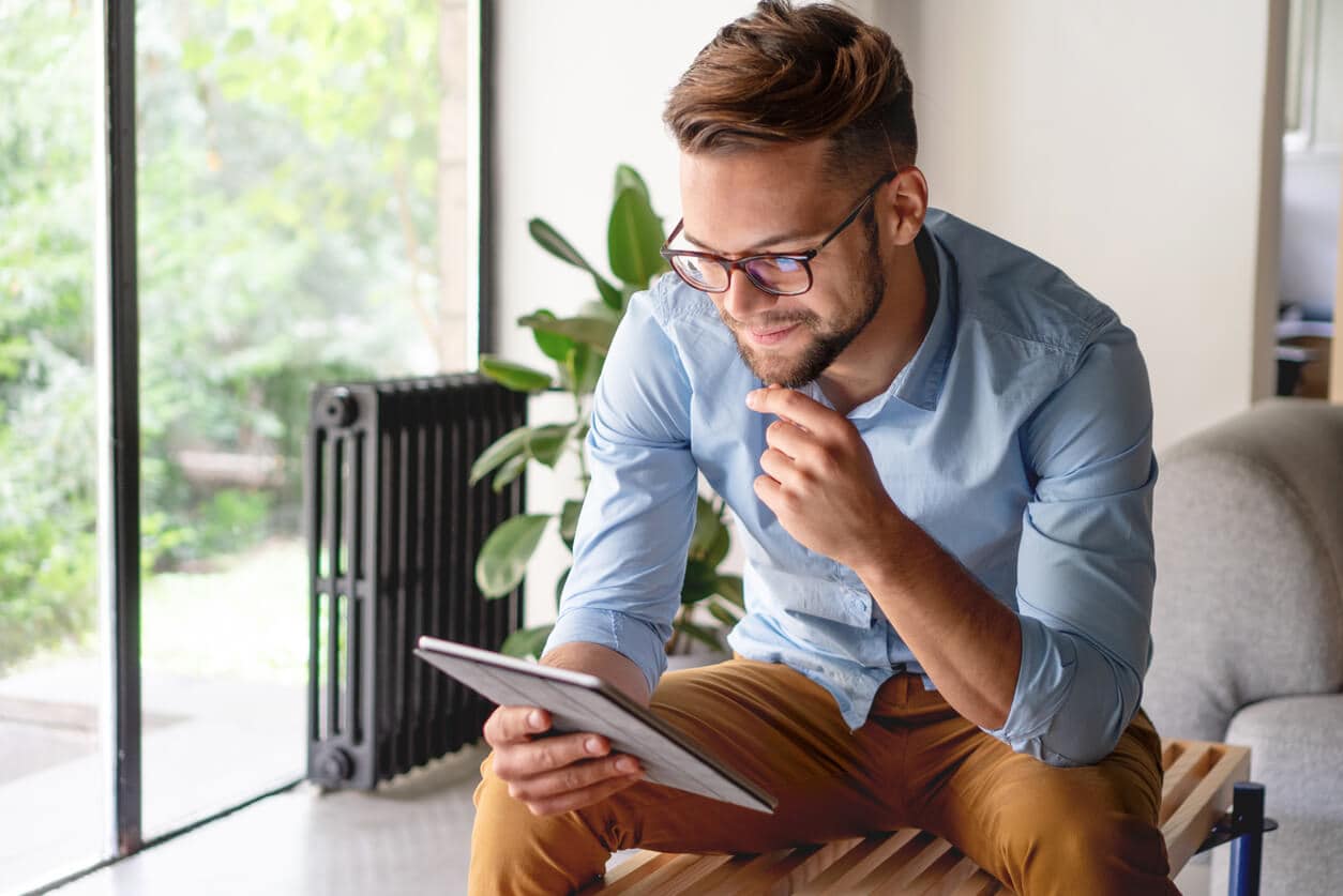 Man sitting  on a bench looking at a tablet