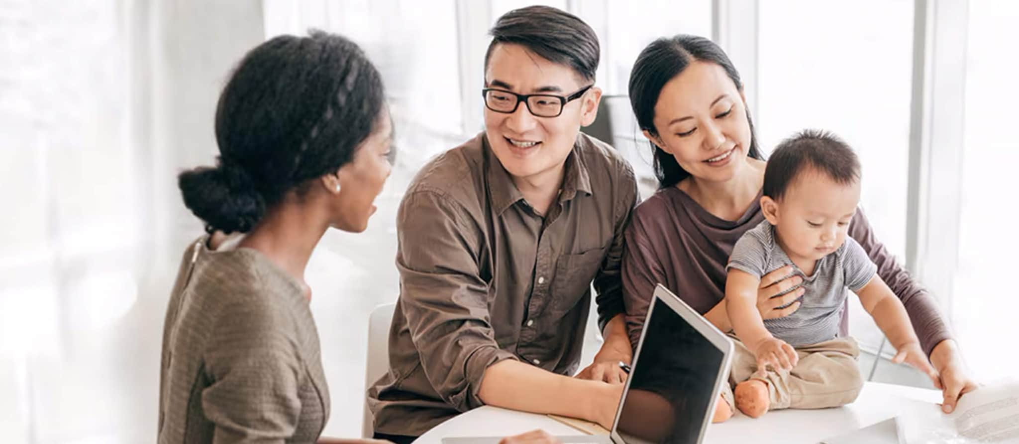 A family of three gathered around a table, engaged with a laptop, discussing home equity line of credit options. A family of three gathered around a table, engaged with a laptop, discussing home equity line of credit options.
