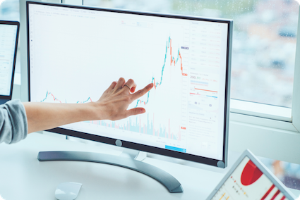 A woman looking at a line graph and observing the business’s highs and lows.